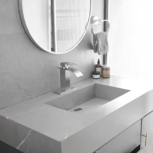 Silver waterfall bathroom faucet installed on a gray bathroom vanity sink